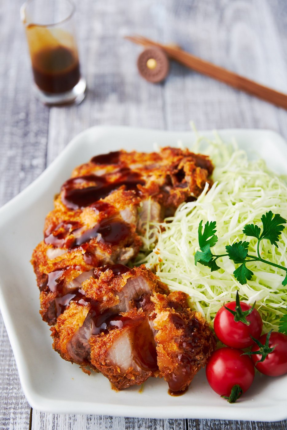 With thick rib-chops coated in a shatteringly crisp layer of panko breadcrumbs, and served with a spiced fruit sauce, Tonkatsu is Japanese home cooking at it's best.