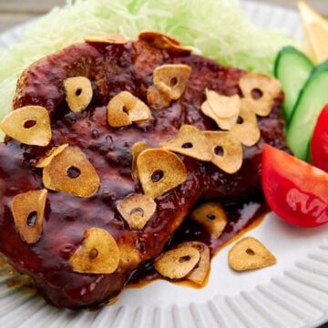 This tender, juicy Japanese pork steak, or Tonteki, is glazed in a savory sweet sauce and topped with crispy fried garlic.