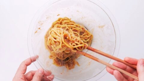 Tossing noodles with garlic sauce.