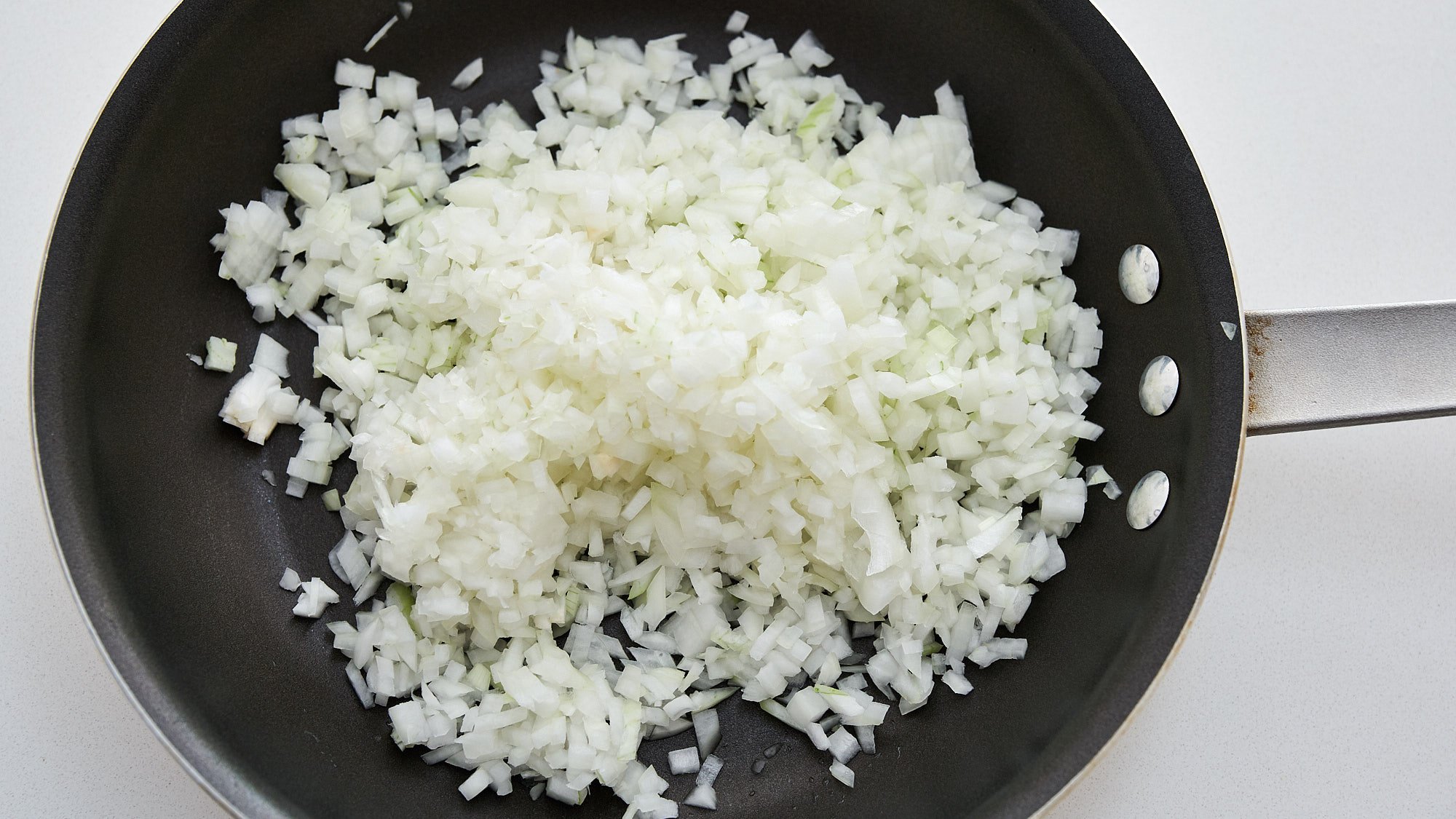 Mincing the onions finely speeds speeds up caramelization and makes it easier to incorporate into the French onion dip.