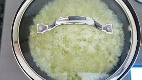 First steam the onions with a lid. This cooks the onions through quickly, helping them to caramelize faster.