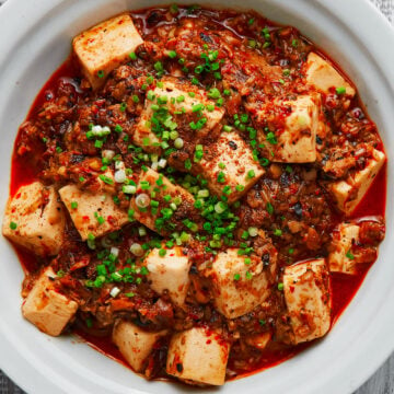 This Vegan Mapo Tofu is loaded with creamy blocks of tofu in a fiery Sichuan sauce made from ground mushrooms and fermented black soybeans.