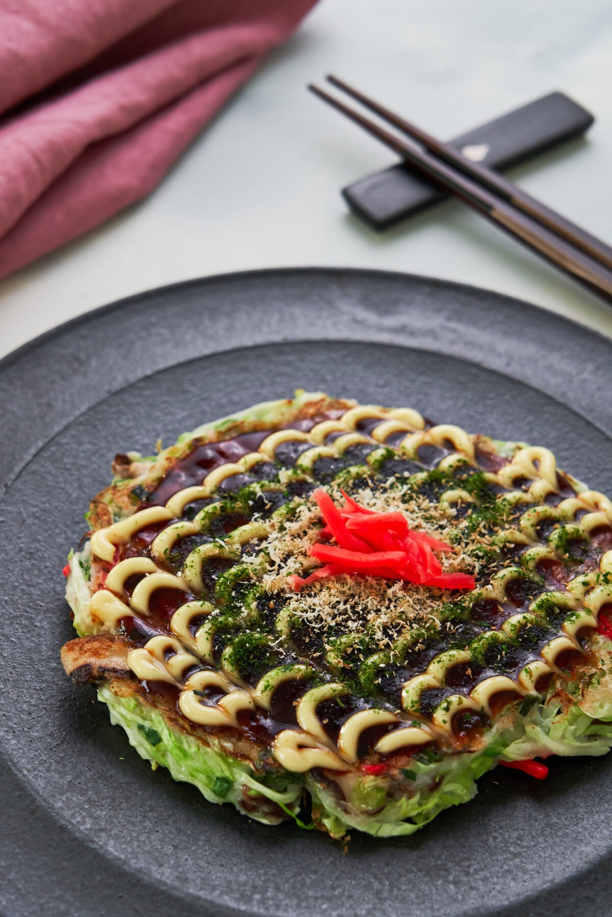 Okonomiyaki is a vegan-friendly Japanese cabbage pancake that can be loaded up and topped with all of your favorite ingredients!