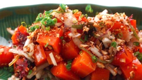 Vegan Poke being garnished with scallions and inamona.