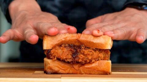 Wagyu Katsu between sandwich bread being pressed down.