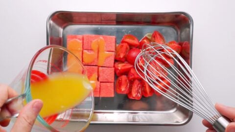 Dressing watermelon and tomatoes for salad.