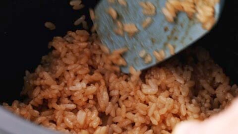 Mixing rice with soy sauce to make yaki onigiri.