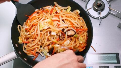 Tossing yaki udon with sauce.