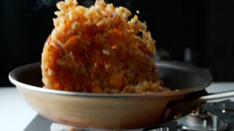 Tossing fried rice in a frying pan.