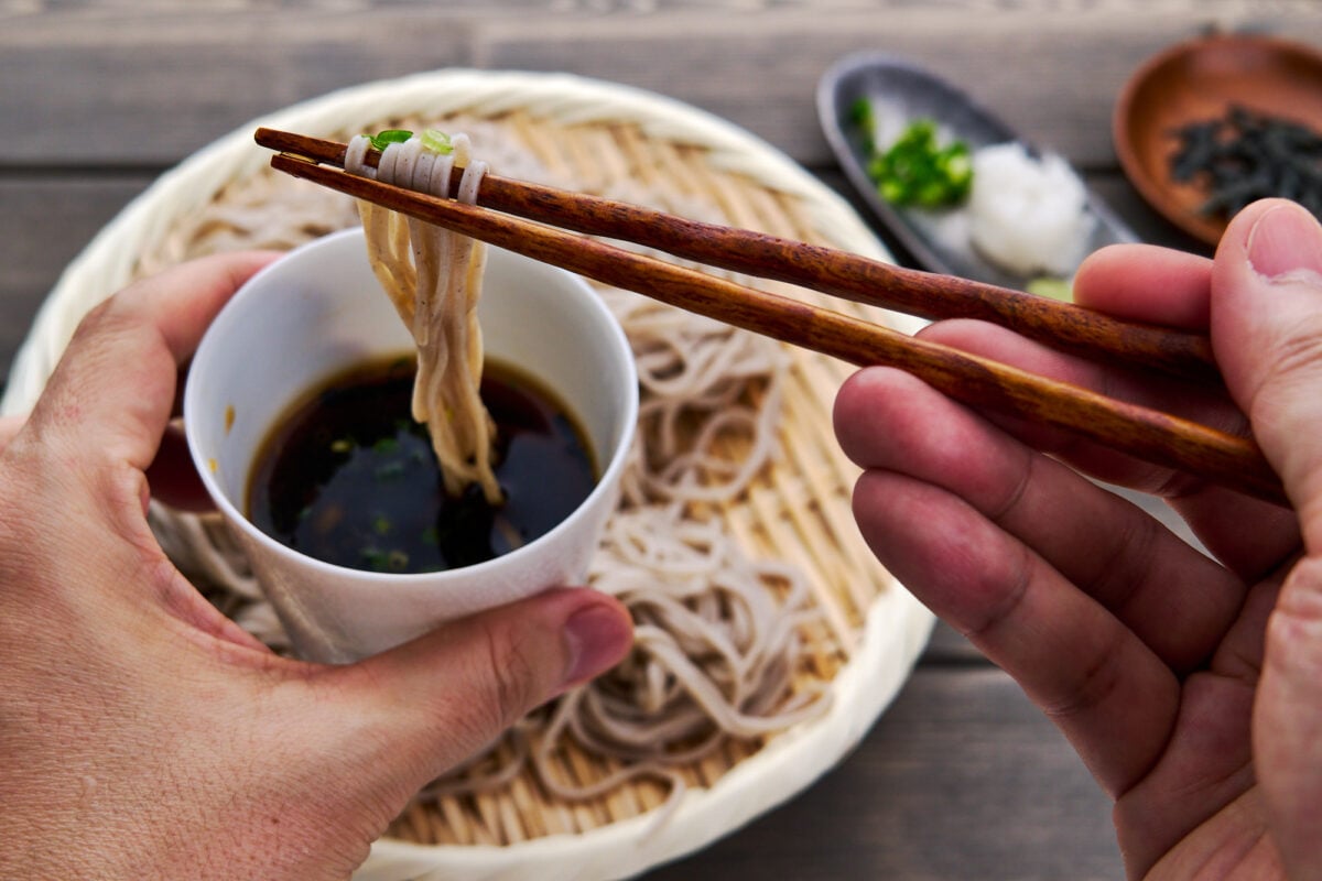 Cold soba noodles get dipped in an umami-packed dashi stock loaded with condiments.