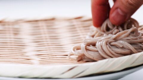 Making mounds of soba on a traditional bamboo zaru.